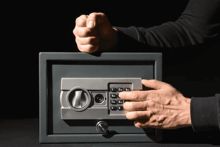 A locksmith technician entering a code on a keypad to open a locked safe for a customer